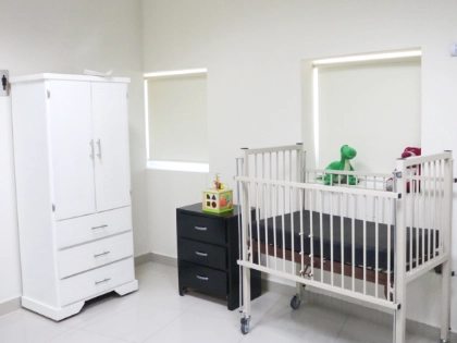 Foto de una sala de infusión pediátrica en la que hay una cuna, decorado y armario para su uso